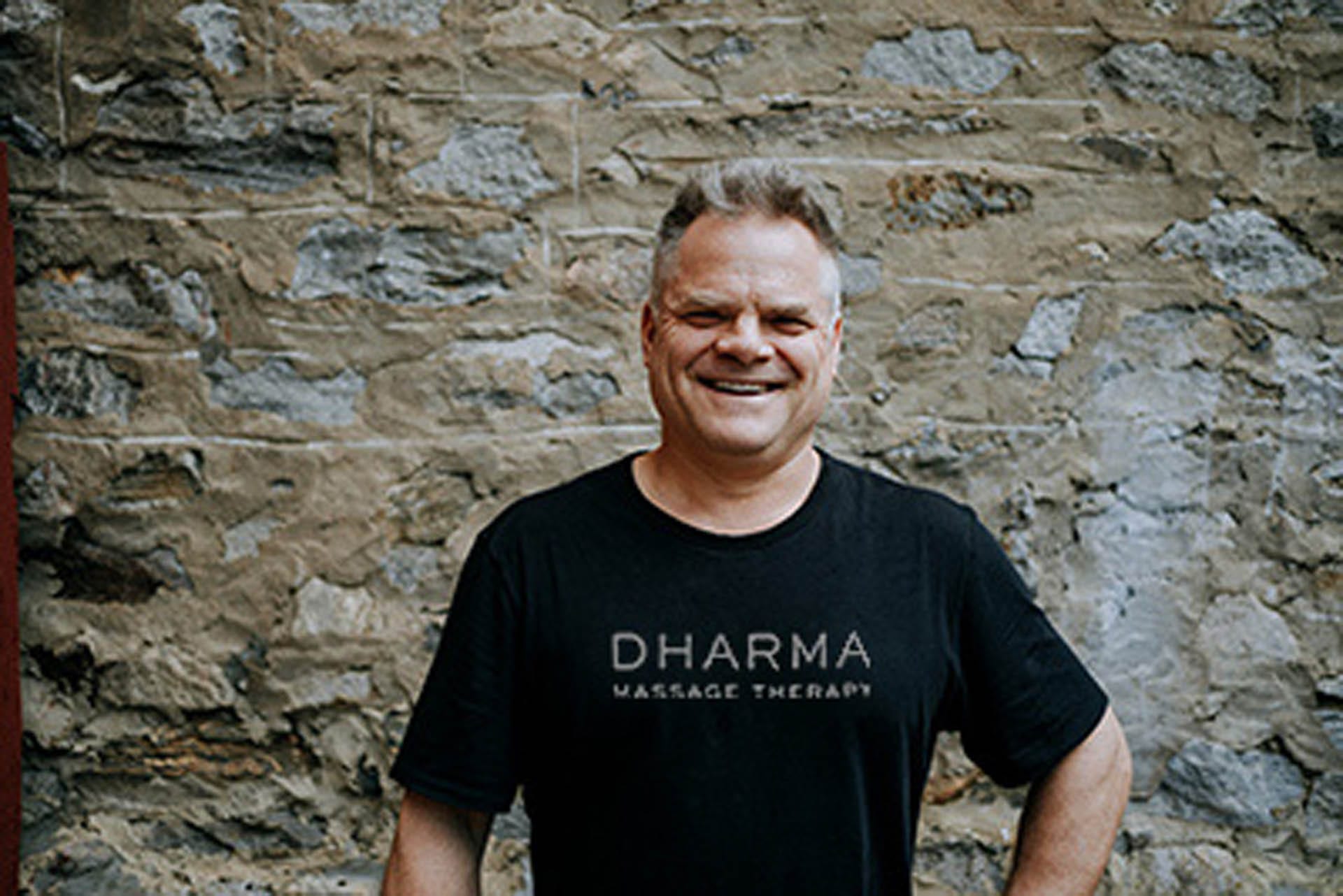 buy-shirts-new Massage therapist Mark standing in Dharma Massage shirt